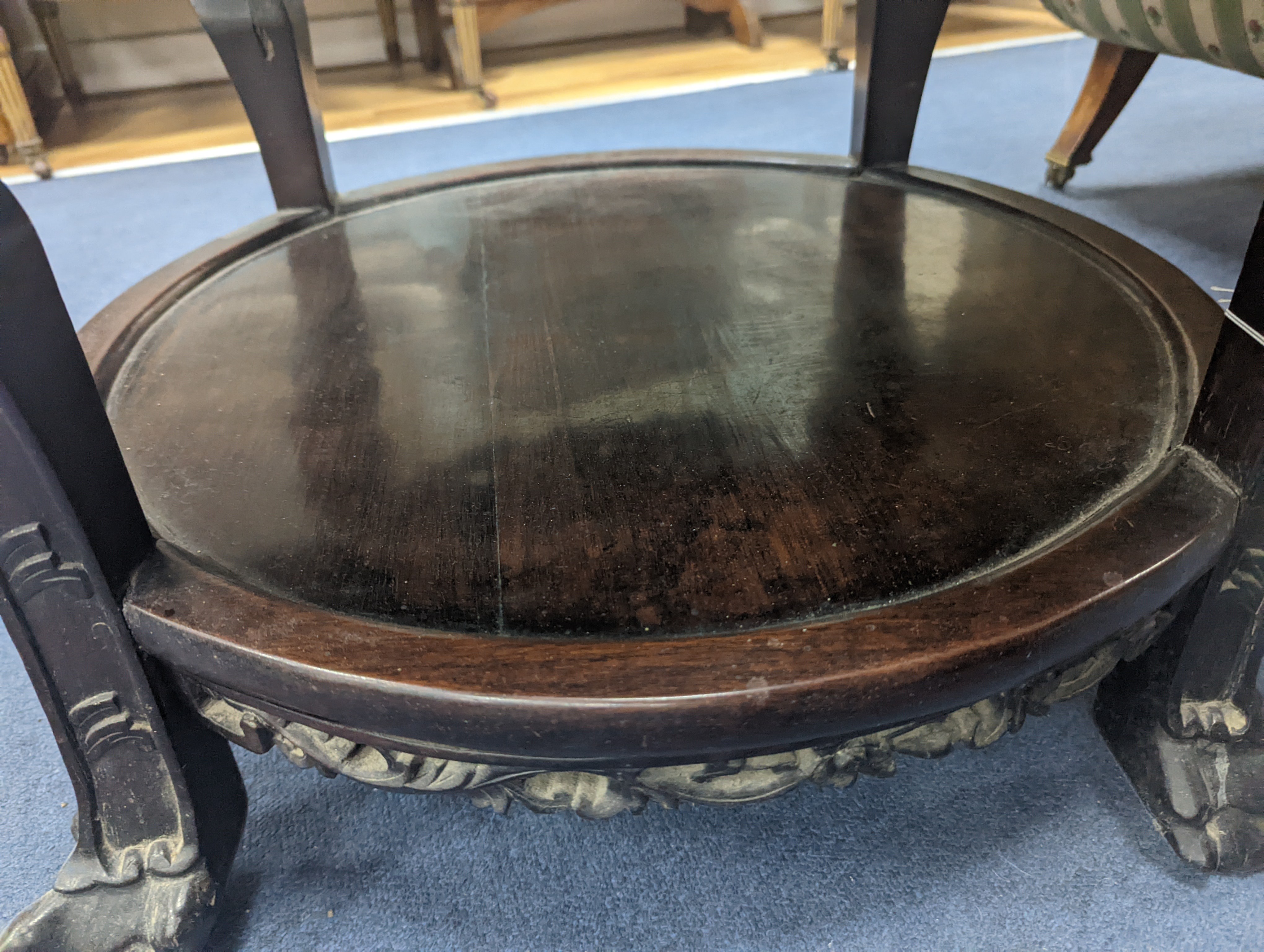 An early 20th century Chinese carved hardwood two tier table, diameter 64cm, height 56cm